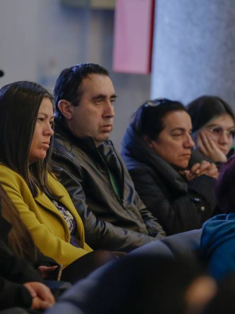 Un grupo de personas sentadas en un evento, mostrando diversas expresiones de atención o reflexión.