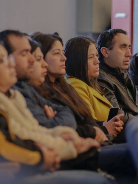 Un grupo de personas escuchando atentamente durante una presentación.
