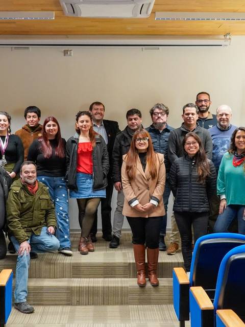Un grupo de personas posando juntas en un auditorio.