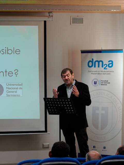 Un hombre habla en un auditorio con una presentación sobre el clima y el planeta.