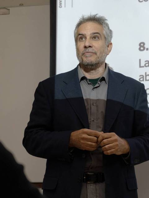 Un profesor expone frente a una pizarra digital sobre el pensamiento creativo y la exploración de ideas originales.