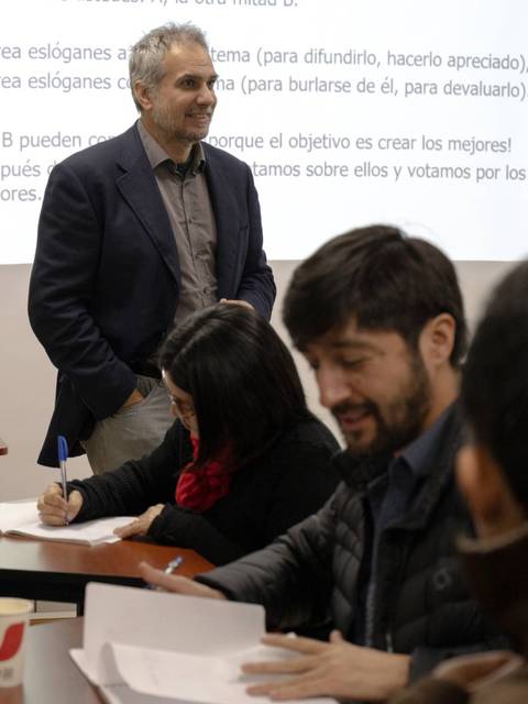 Una sesión de trabajo grupal en la que un facilitador guía a los participantes mientras discuten en una clase.