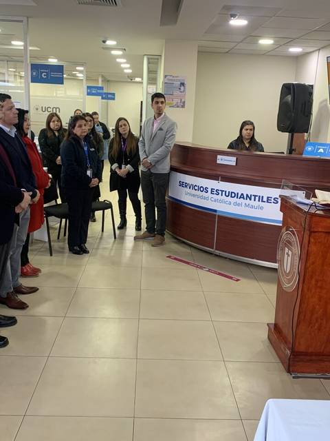 Un grupo de personas asisten a una ceremonia en un establecimiento educativo.