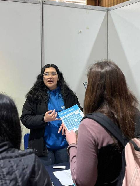 Estudiantes de la Universidad Católica del Maule informando sobre la Facultad de Medicina en un evento.