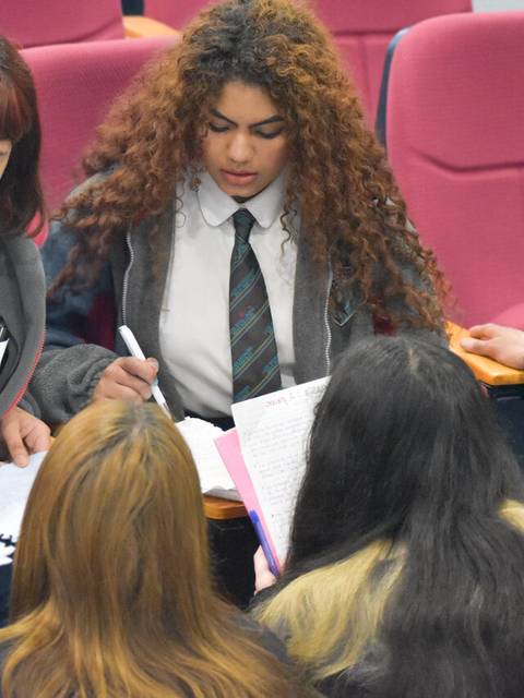 Un grupo de estudiantes colabora en una actividad académica en un aula.