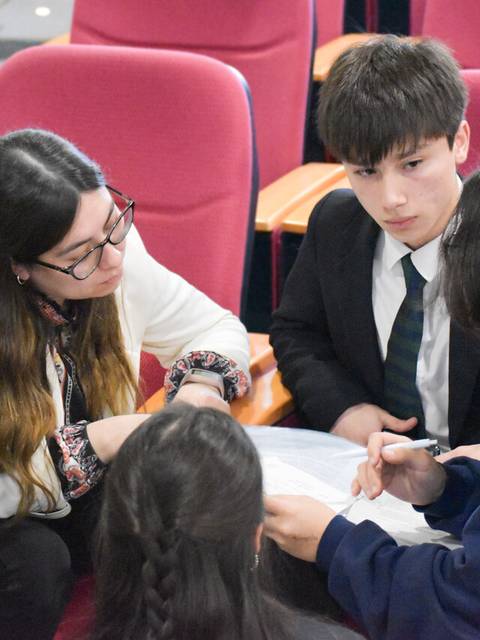 Un grupo de estudiantes discutiendo y colaborando en un proyecto en un aula.