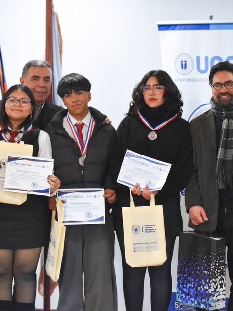 Un grupo de jóvenes recibe reconocimientos en un evento formal.