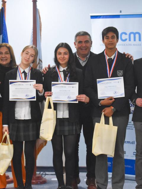 Grupo de jóvenes posando después de recibir premios y certificados en un evento.