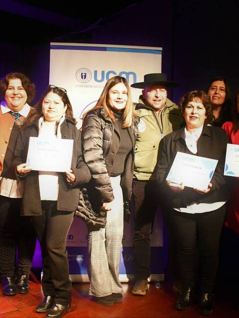 Un grupo de personas sonríe mientras sostienen certificados en un evento de premiación.