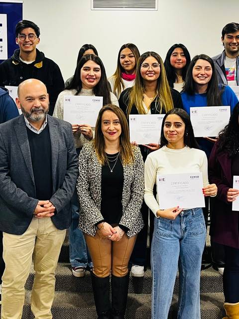 Grupo de estudiantes posando con certificados en un evento académico.