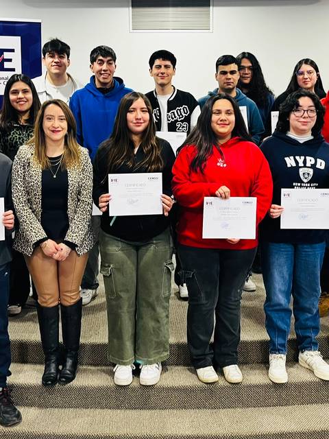 Un grupo de estudiantes sostiene certificados en un evento celebrado en una institución educativa.