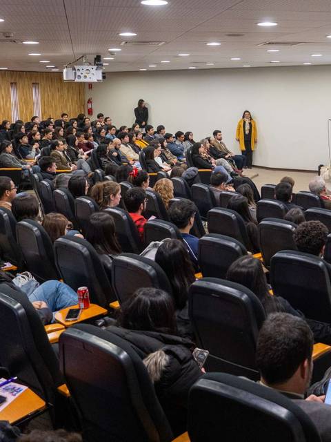 Una sala llena de personas asistiendo a una presentación.