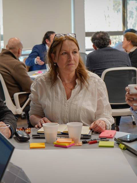 Un grupo de personas participando en una reunión colaborativa en un ambiente de oficina.