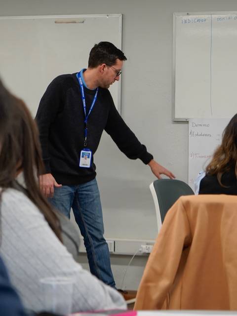 Un grupo de personas asiste a una presentación en un aula moderna.