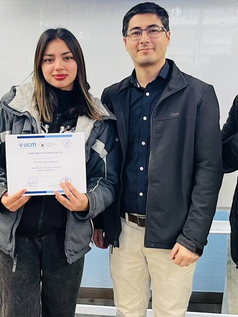 Un grupo de personas celebra la entrega de un certificado a una joven.