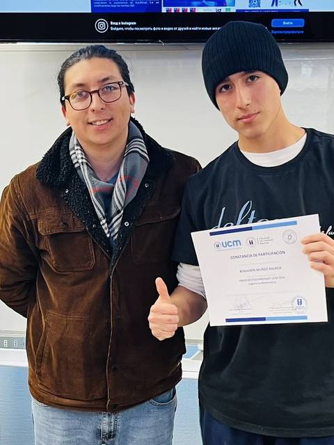 Un grupo de personas celebra la entrega de un certificado en un evento formal.