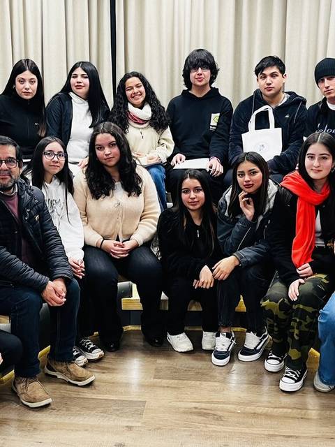Grupo de personas posando en una sala con un ambiente amigable.