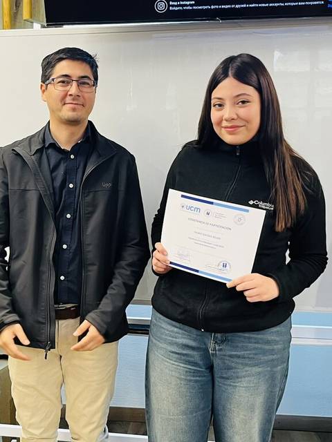 Un grupo de personas celebra la entrega de un certificado a una joven.