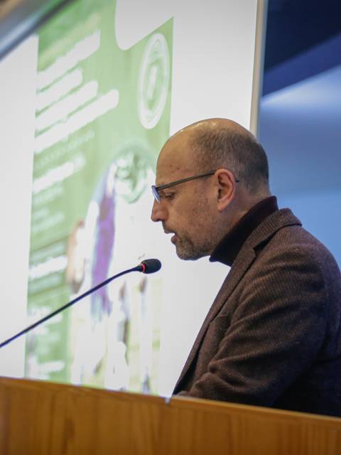 Un hombre está dando una presentación en un evento académico.