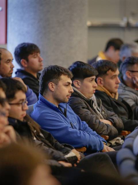 Un grupo de jóvenes escuchando atentamente en una conferencia.