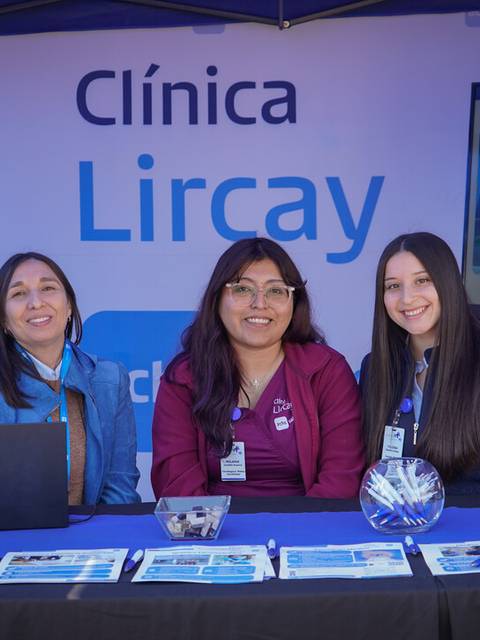 Tres mujeres sonríen desde un stand de la Clínica Lircay.