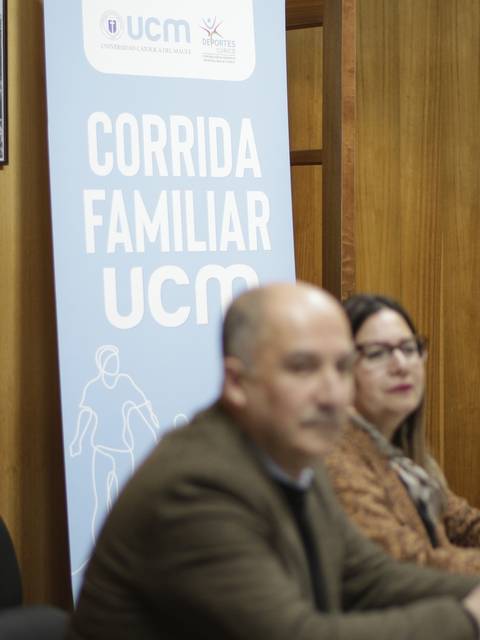 Una reunión con un banner que promociona la 'Corrida Familiar UCM'.