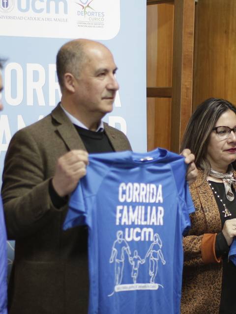Varios participantes sostienen camisetas promocionales de un evento deportivo familiar.