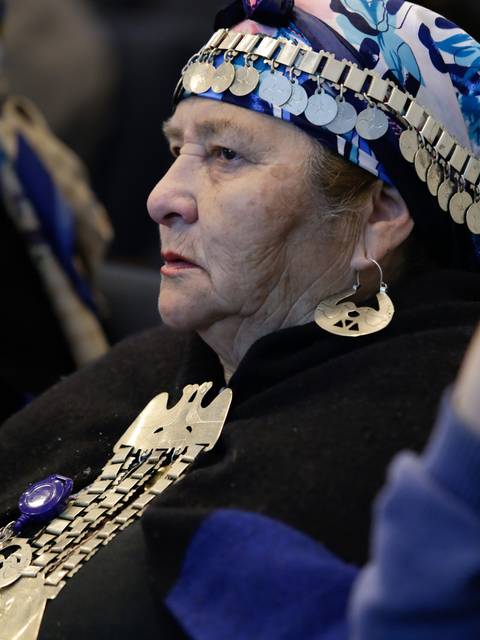Una mujer mayor con vestimenta tradicional y accesorios ornamentales que reflejan su cultura.