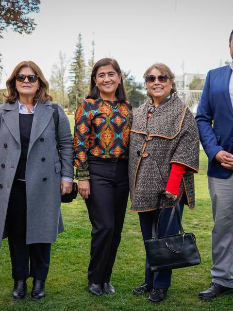 Un grupo de cinco personas posando en un parque durante un día soleado.