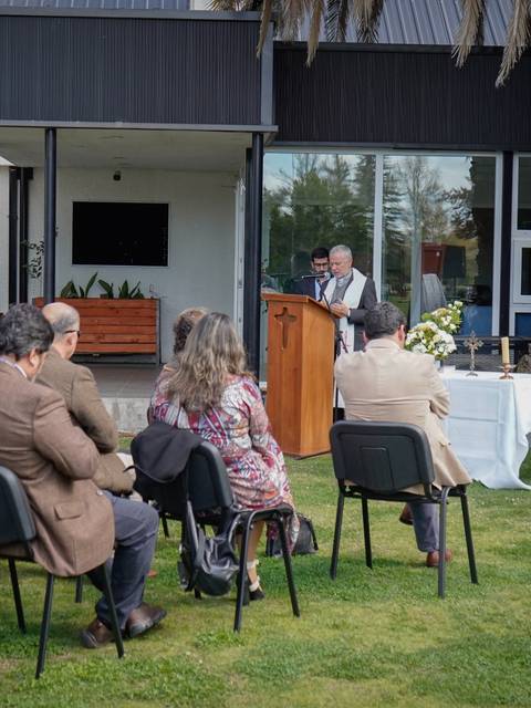 Un grupo de personas asistiendo a un discurso al aire libre frente a un ícono religioso.