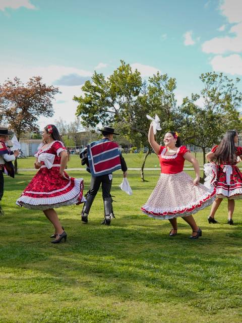 Un grupo de personas bailando en un ambiente al aire libre con vestimenta tradicional.