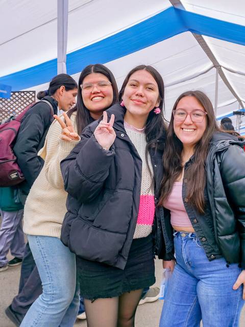 Un grupo de chicas posa sonriente en un ambiente festivo bajo una carpa.