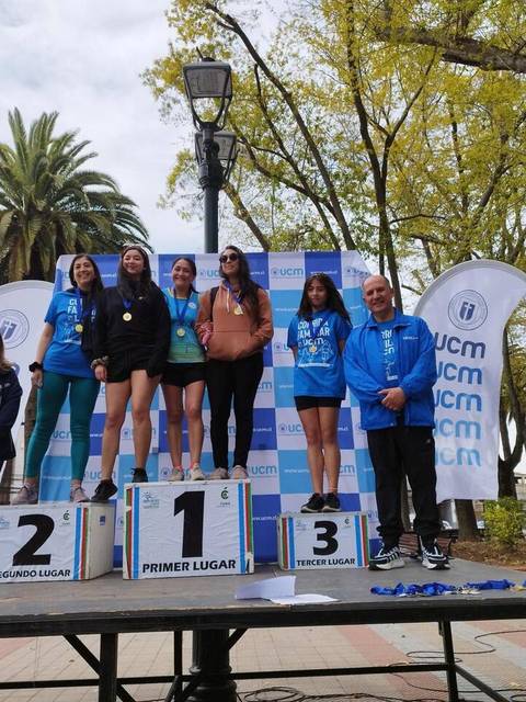 Un grupo de personas celebra en un podio de premiación tras una competencia deportiva.