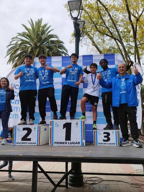 Un grupo de jóvenes atletas celebra en el podio tras una competencia deportiva.