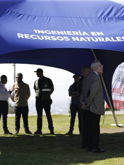 Un grupo de personas se reúne bajo una carpa que promociona la ingeniería en recursos naturales.