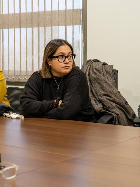 Un grupo de personas sentadas alrededor de una mesa en una reunión.