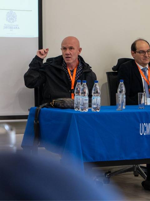 Dos ponentes discuten durante una conferencia en un aula.