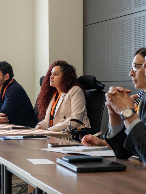 Un grupo de personas sentadas en una mesa durante una reunión.