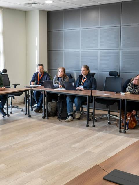 Un grupo de personas asiste a una presentación en una sala de reuniones.