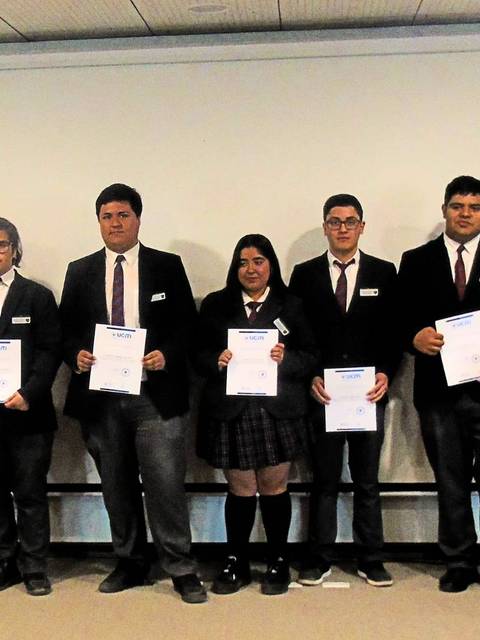 Un grupo de estudiantes posando con certificados en un evento académico.