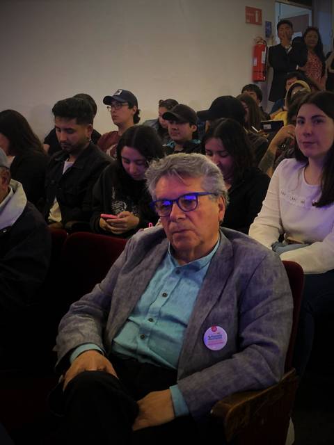 Un grupo de personas sentadas en un auditorio durante un evento.