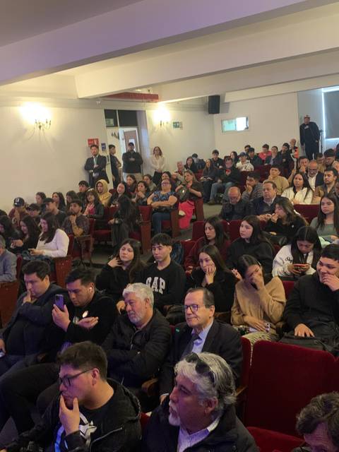 Una multitud de personas sentadas en un auditorio durante un evento.