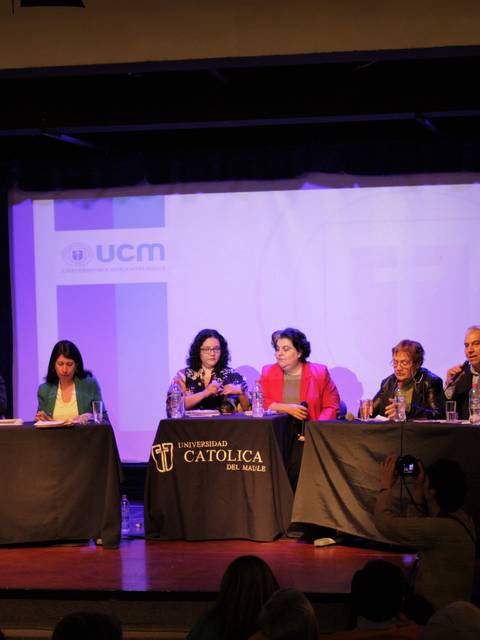 Un panel de seis personas sentadas en el escenario durante un evento académico.