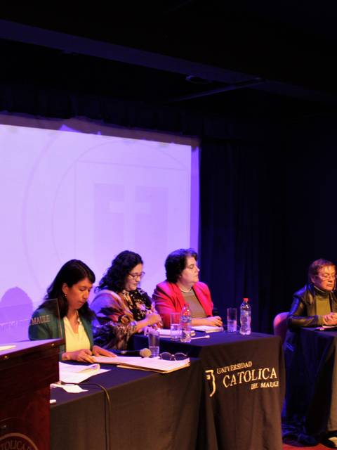 Una mesa de debate con varios ponentes y un público atento.