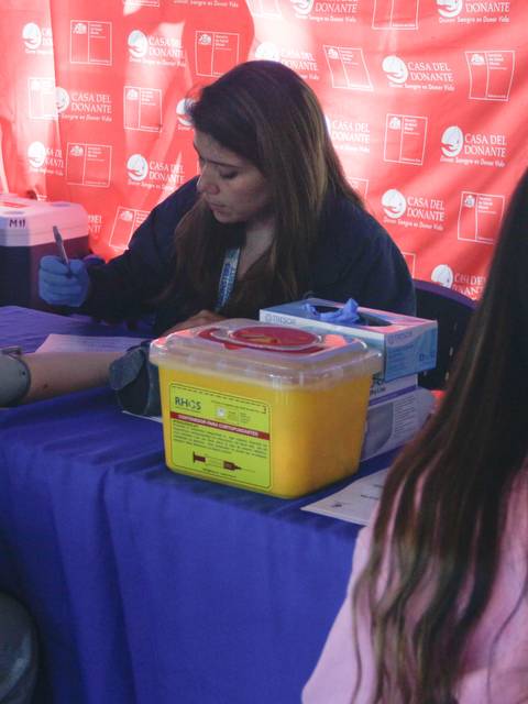 Un grupo de personas participa en un servicio de salud donde se mide la presión arterial.
