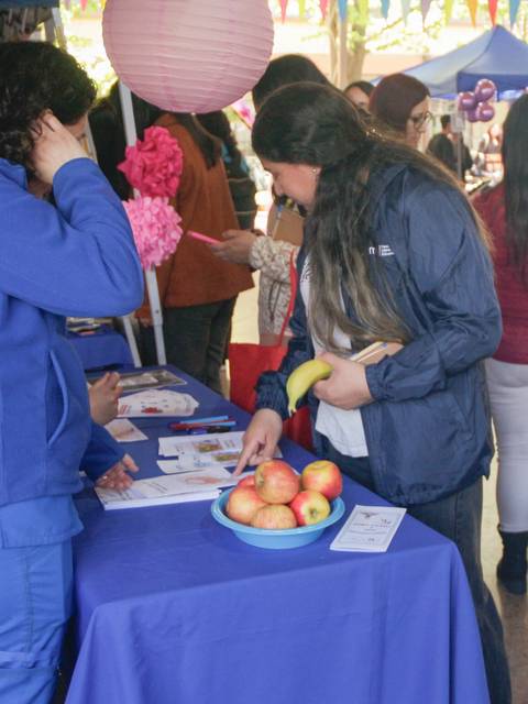 Una feria con personas interactuando en un ambiente festivo y colorido.