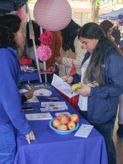 Una feria con varias personas interactuando en un ambiente festivo y colorido.