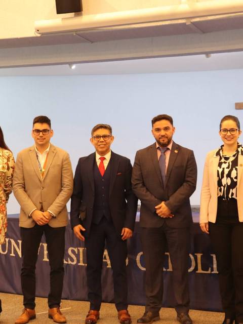 Un grupo de seis personas posando en un evento en la Universidad Católica del Maule.