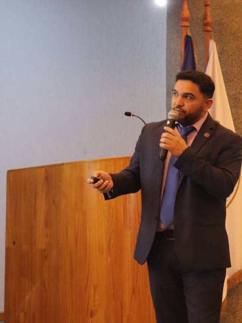 Un hombre presenta en un evento con una pizarra en el fondo.