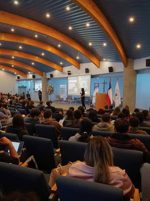 Un auditorio lleno de estudiantes prestando atención a una presentación.